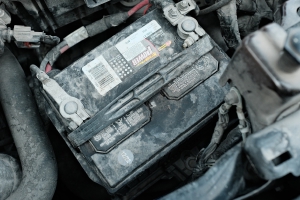 a dirty car battery from a Jeep Patriot connected to the car