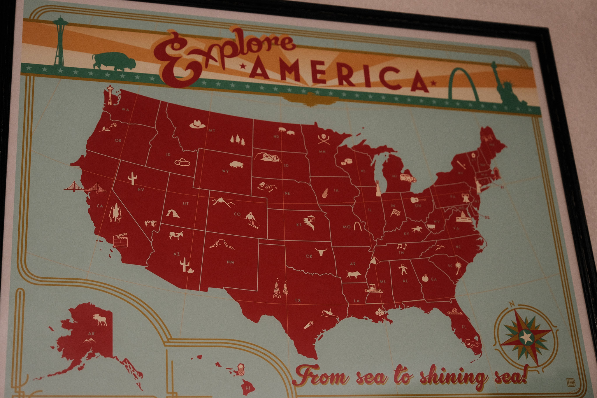 a poster by Anderson Design Group of a map of the United States with the title of ‘Explore America’ at the top and ‘From Sea to Shining Sea’ at the bottom