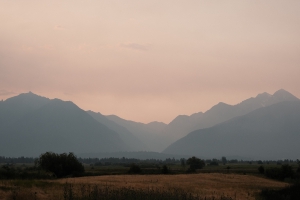 a view of the mid-morning mission mountains thick with a red and smokey haze