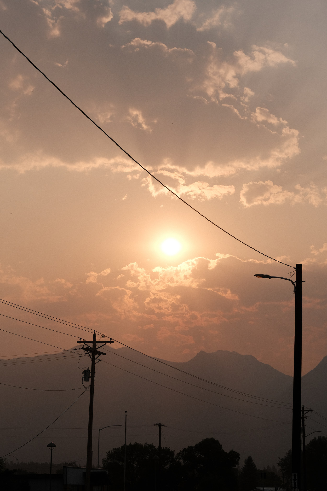 an early morning sun over the mountains, red with the smoke from nearby fires