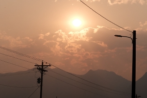 an early morning sun over the mountains, red with the smoke from nearby fires