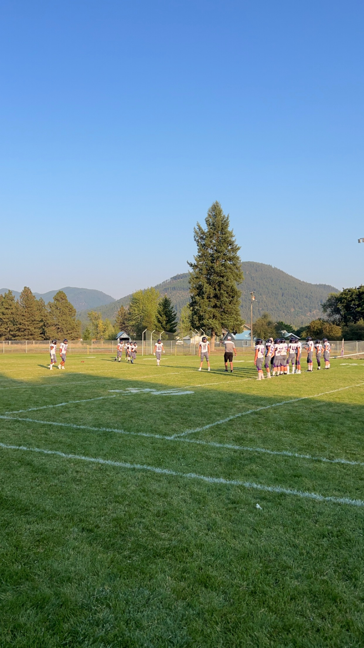 Vikings football team on the football field with a coach instructing them