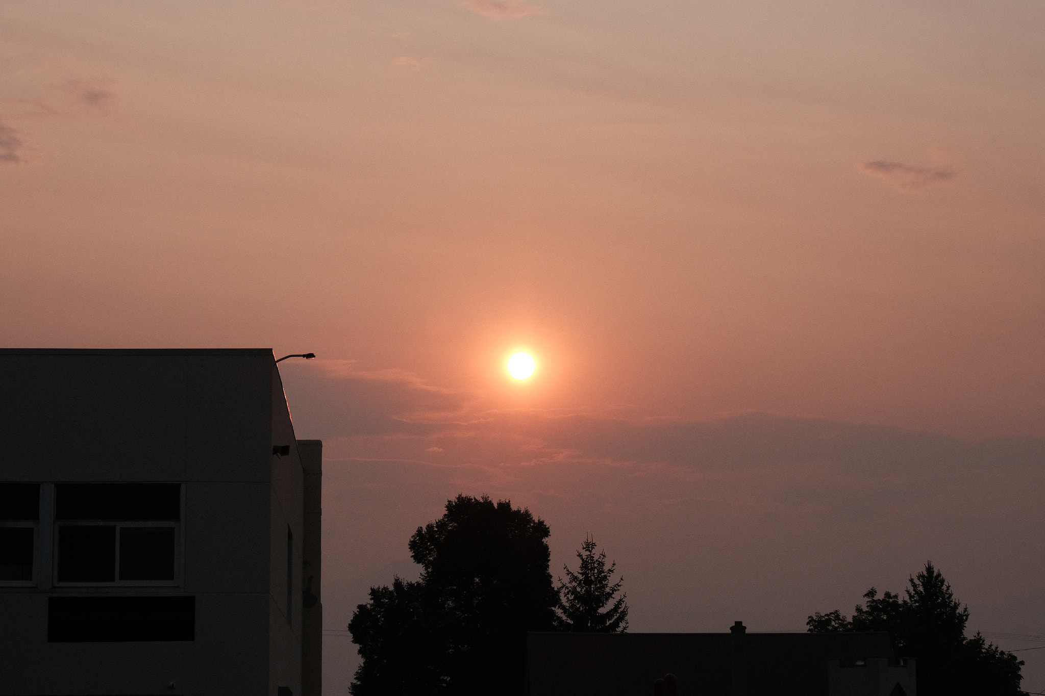 Early morning sunrise. The sky is thick with fire smoke and casting an orange and red glow to the scene