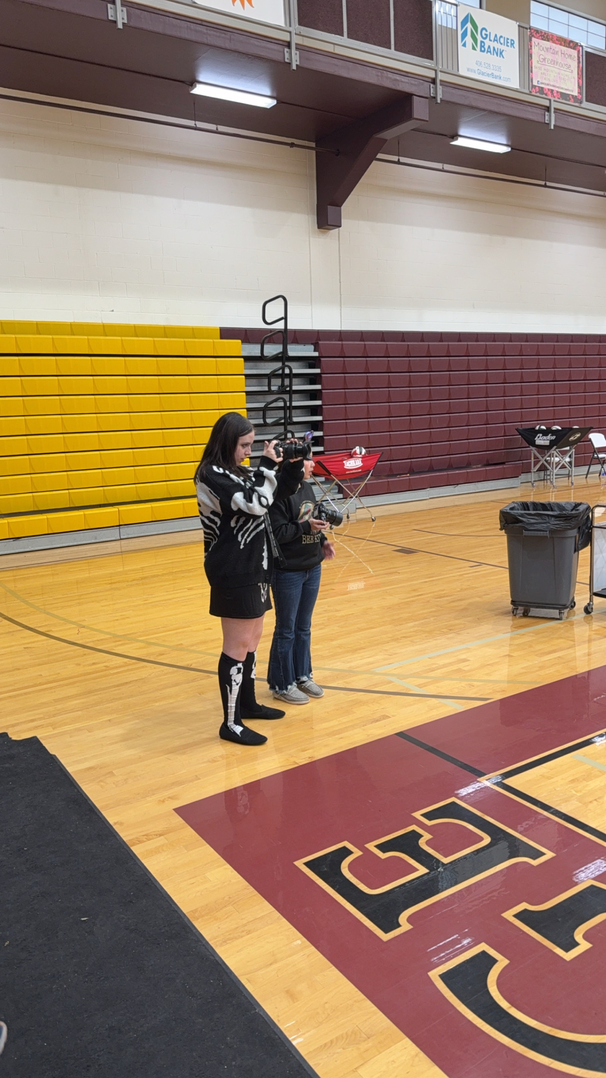 Two girls taking photos with two Fujifilm cameras at a local district volleyball tournament