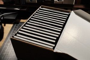 A custom cardboard wooden box with 15 completed Leuchtturm1917 notebooks organized inside, a white label across each spine with the start and end dates of each notebook